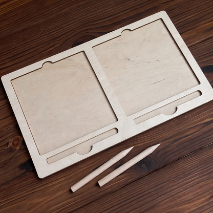 Wooden drawing board with two tablets and two pencils on a wooden surface