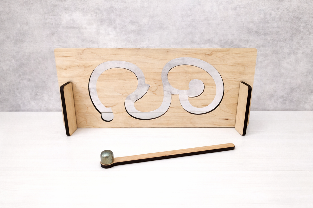 Wooden anvil with metal shapes and a hammer on a white surface
